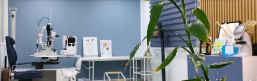 Salle d'examen du cabinet : lampe à fente, fauteuil et échelle de lecture